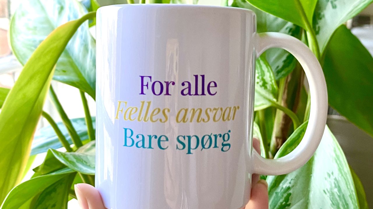 billede af kop med Byens hus motto for alle/fælles ansvar/bare spørg