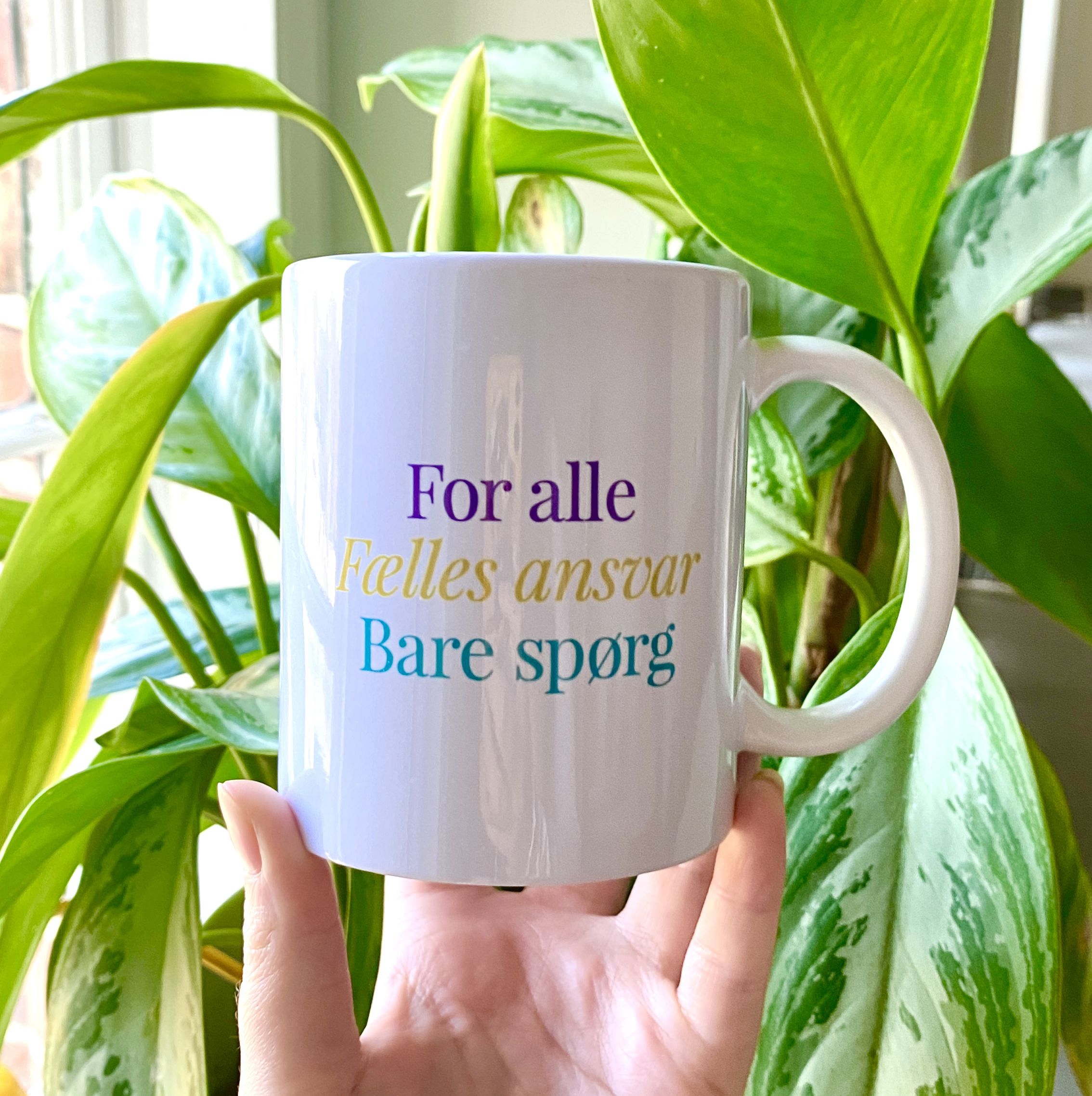 billede af kop med Byens hus motto for alle/fælles ansvar/bare spørg